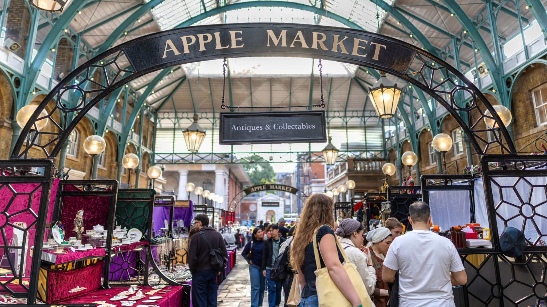 Hunt for special one-of-a-kind gifts at Covent Garden's Apple Market, which once sold fruit and vegetables. Credit: London & Partners/Peter Cohen. Image courtesy of visitlondon.com. A photo of people walking around the stalls at Apple Market inside the Covent Garden piazza with different stalls selling handmade goods