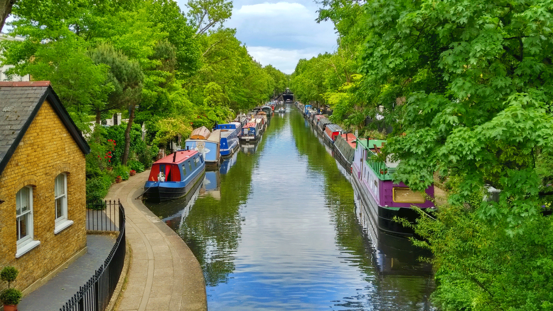Image of boats and river surrounded by leafy trees in Little Venice
