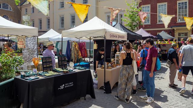 Visitors browsing stalls at Duck Pond Market in Richmond, with jewellery, clothing and food on display.