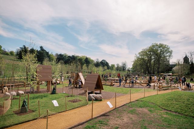 Children playing at Petersham Gate playground surrounded by trees and open green space.