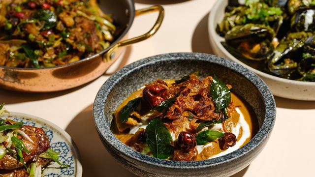 Chicken gassi dish at Kricket restaurant in Soho, with other dishes in the background.