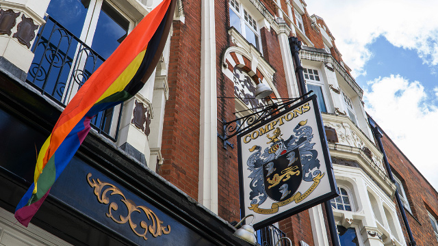 Comptons pub sign with LGBTQ+ flag in Old Compton Street, Soho, London.