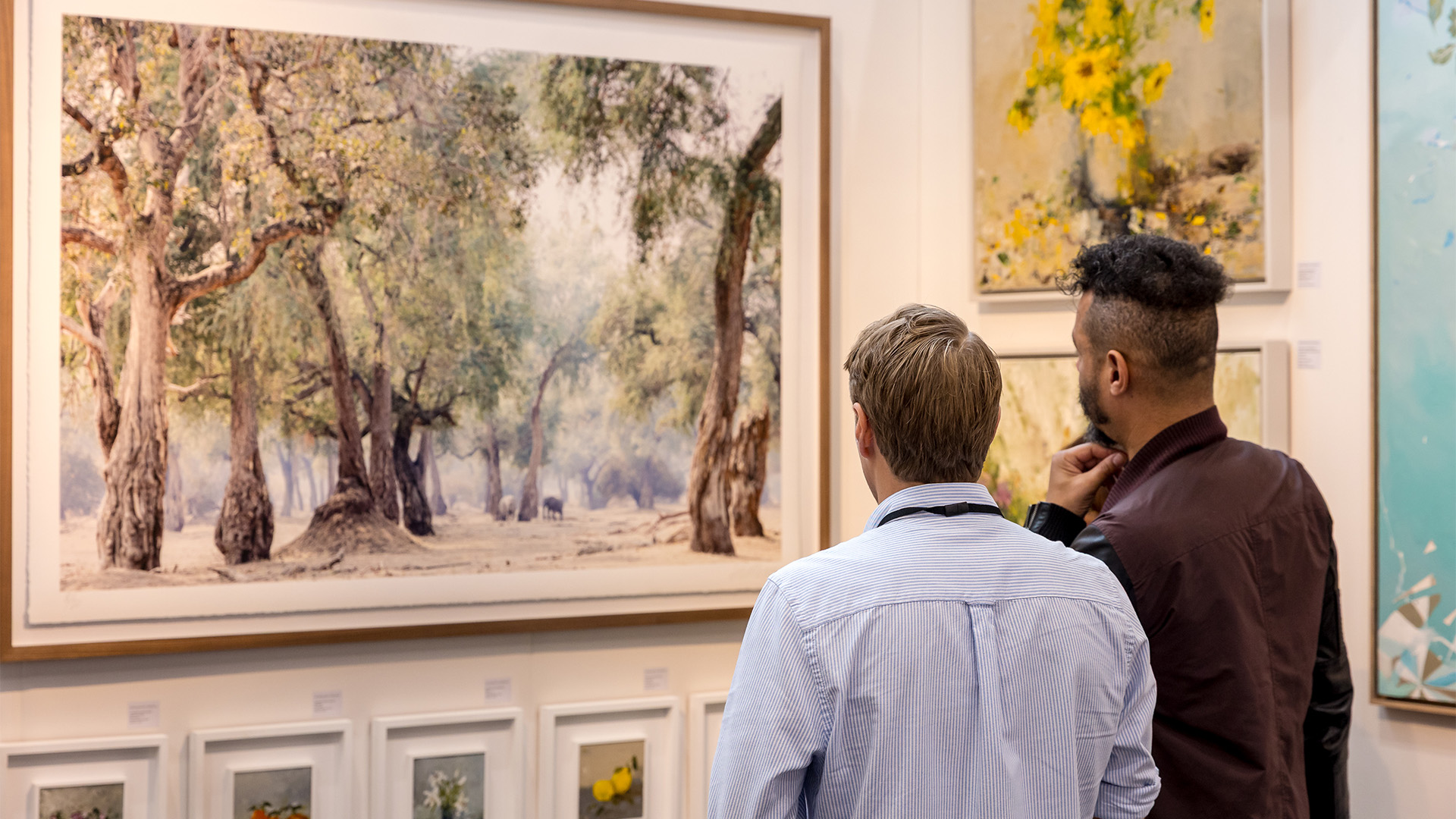 Discover new artworks at Battersea Affordable Art Fair. Image courtesy of Battersea Affordable Art Fair. Two people looking at a painting at Battersea Affordable Art Fair