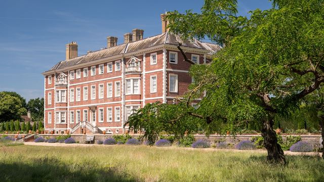 Ham House, a historic red-brick house surrounded by gardens and trees in Richmond, London
