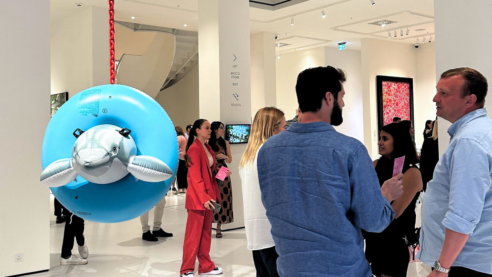 Crowds stand next to Dolphin Taz Trashcan, the metal inflatable artwork by jeff koons