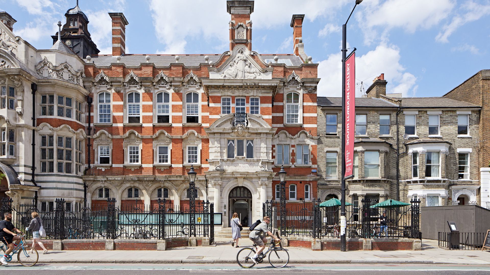 Exterior of South London Gallery with person riding bike outside.