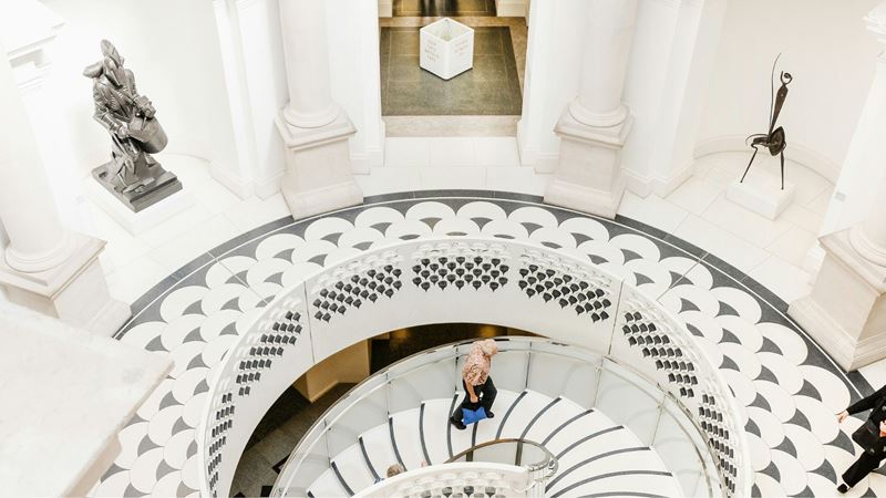 Spiral staircase with person walking up it at Tate Britain.