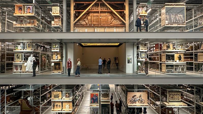Be immersed in the artefacts of the V&A East Storehouse's impressive archive collection. Credit: Kirstine Spicer. Image courtesy of visitlondon.com. Three floors of the V&A East Storehouse with people walking among the shelves.