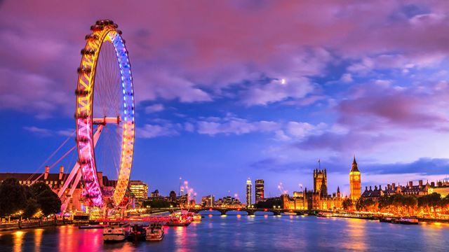Vues sur la Tamise avec les Chambres du Parlement et le London Eye illuminés, alors que la nuit commence à tomber sur la capitale. 