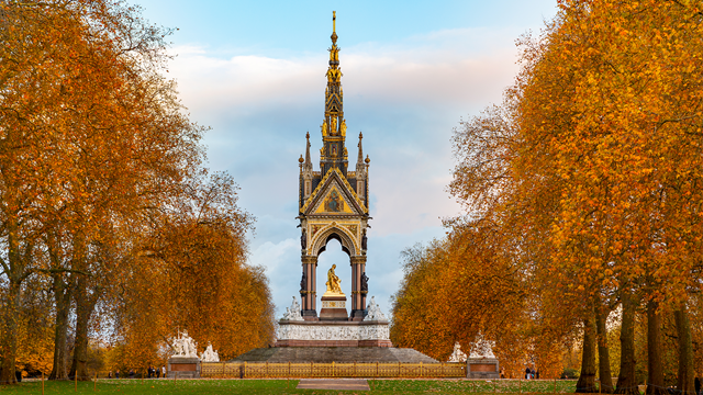 Albert Memorial at Kensington Gardens in London surrounded by trees with autumn foliage.
