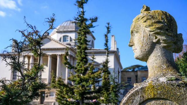 A statue stands beside the grand Chiswick House in London. 