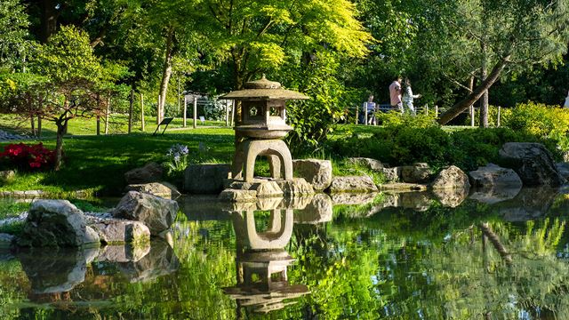 The Kyoto Garden pond with the reflection of a stone lantern in the water
