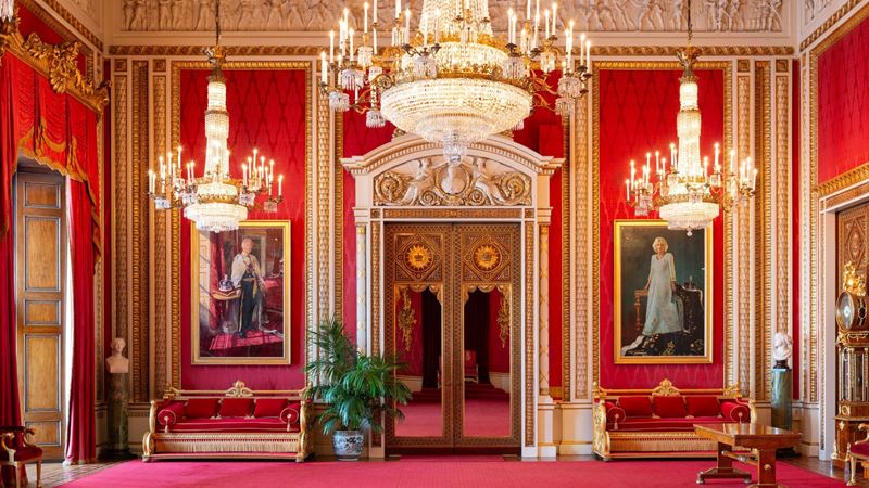 Be captivated by the grand interiors and get up close with royal portraits in the Throne Room at Buckingham Palace. Image credit: Royal Collection Trust. Image courtesy of the Royal Collection Trust. An opulent rec throne room with chandeliers and portraits at buckingham palace.