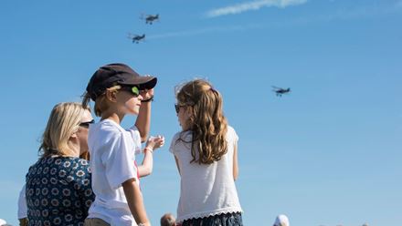 Children watch historic aircraft fly overhead during an air show at IWM Duxford. Image courtesy of Golden Tours.