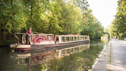 A canal boat on the Regent's Canal. Credit: Aaron Marcus Sutton. Image courtesy of London Waterbus Co.