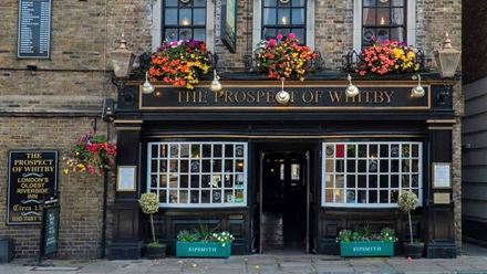 The outside of the pub decorated with hanging baskets and planters. Image courtesy of Greene King.