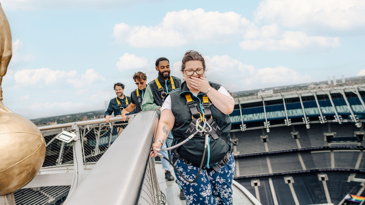 Atteignez de nouvelles hauteurs en participant au Dare Skywalk et retrouvez-vous face au fameux coq d'or se tenant au sommet du stade de Tottenham Hotspur. © visitlondon.com/Michael Barrow Une jeune femme se tient à la rampe alors qu'elle se trouve sur le toit du stade Totthenham Hotspur.