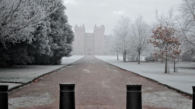 Windsor Castle viewed from the Long Walk on a frosty winter morning with bare trees.