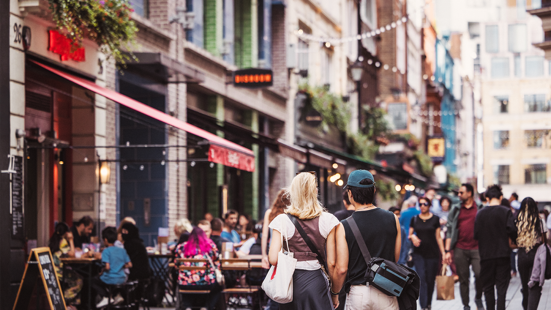 A couple walk hand-in-hand through Carnaby 