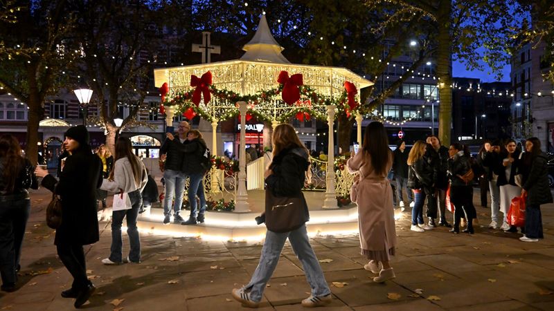 Head to Chelsea for a spot of luxury and high street shopping this Christmas. Credit: Chelsea. Image courtesy of Chelsea. A bandstand in the middle of a square in Chelsea lit up with warm twinkling lights and giant red velvet bows at night as people stroll past