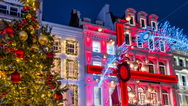 Weihnachtsbäume und beleuchtete saisonale Schaufenster in Mayfair, London 