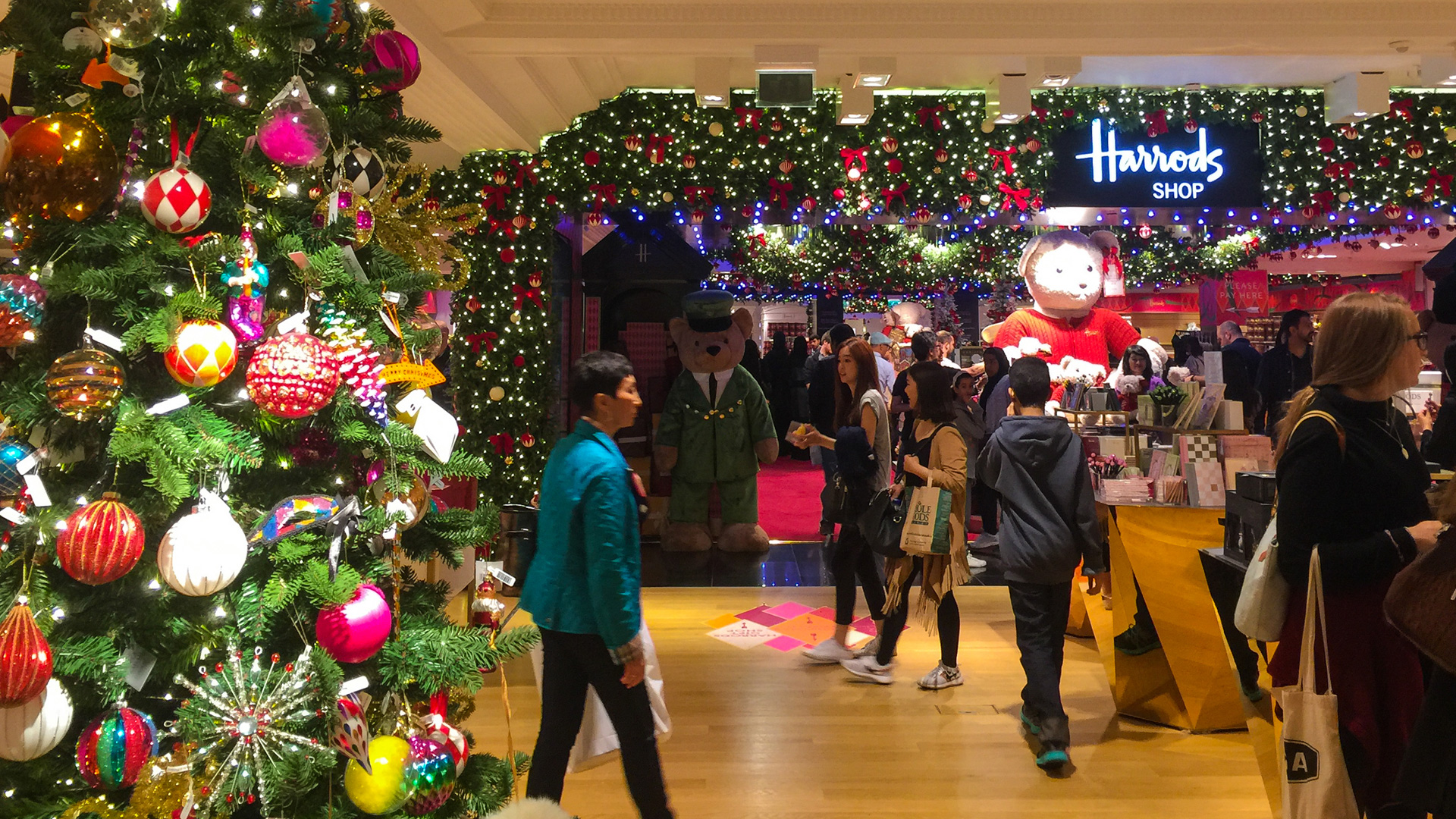 Find the perfect gift in the Harrods Christmas Shop © Roger Utting. Image courtesy of Shutterstock. The colourful interior of Harrods at Christmas time with a decorated Christmas tree in the foreground with the Christmas Shop and people walking around in the background