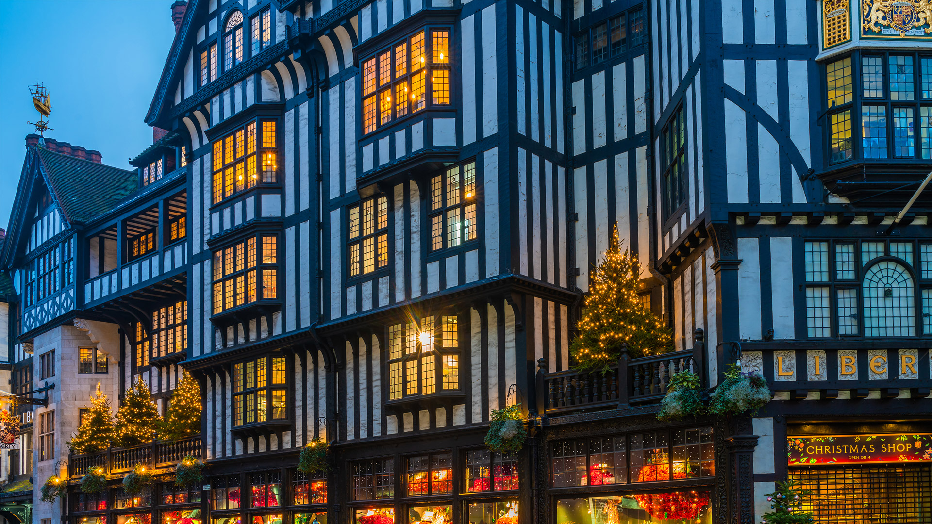 Take time to explore each floor of this beautiful store during your visit © BBA Photography. Image courtesy of Shutterstock. The Tudor-style black and white exterior of Libery London at Christmas time, with its windows illuminated from inside.