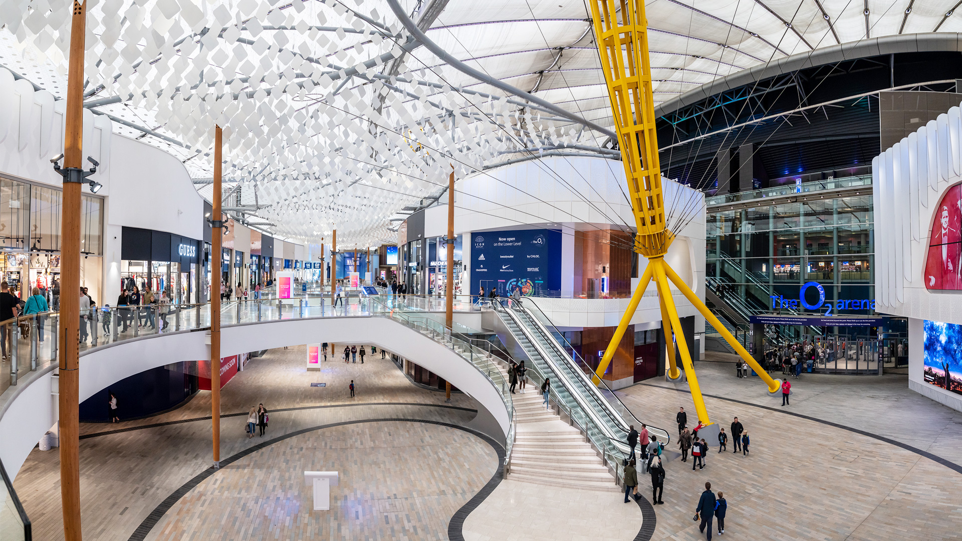 The spacious circular interior of Outlet Shopping at The O2 with The O2 Arena in the background