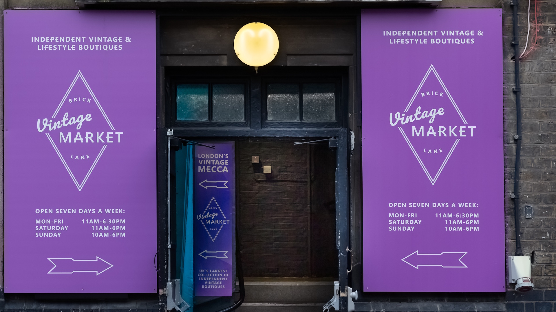 Entrance and purple signs outside The Vintage Market in the Old Truman Brewery building on Brick lane.
