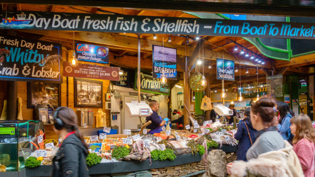 Meeresfrüchtestand um Borough Market. Personen kaufen frischen Fisch im Borough Market in London.