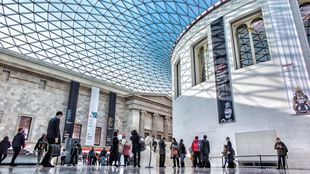 Des visiteurs se trouvent dans la grande cour du British Museum et son dome bleuté.