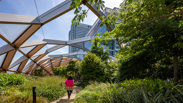 Une femme se promène dans les jardins du toit de Crossrail Place