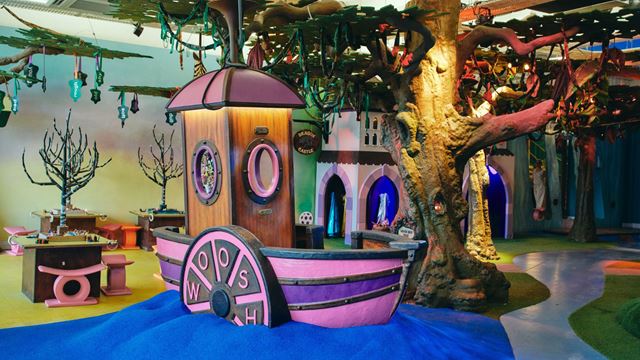 A colourful indoor play space at Discover Children's Story Centre featuring a pink play boat, a giant tree, castle-themed play areas and interactive storytelling activities for young children.