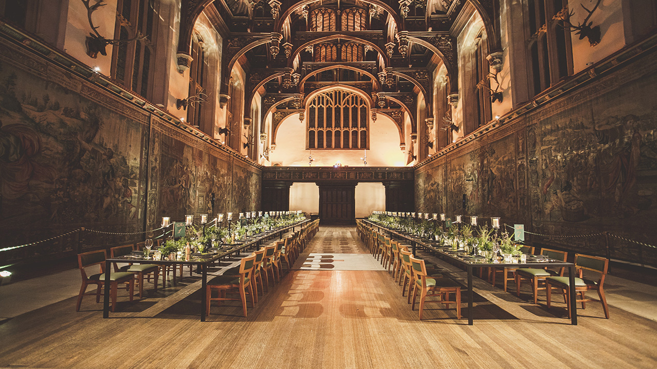 Roam the great hall of Hampton Court Palace and see where Henry VIII hosted parties. Image courtesy of Historic Royal Palaces © Historic Royal Palaces The great hall of Hampton Court Palace lined with medieval tapestries and two long tables prepapred for a feast. The ceiling shows an impressive gothic-style architecture.
