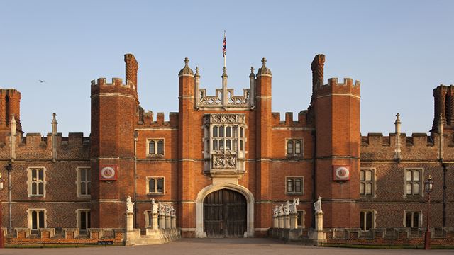 Red Tudor-style architecture of Hampton Court Palace''s Great Gatehouse, with turrets and a large entry from the courtyard at the West Front.