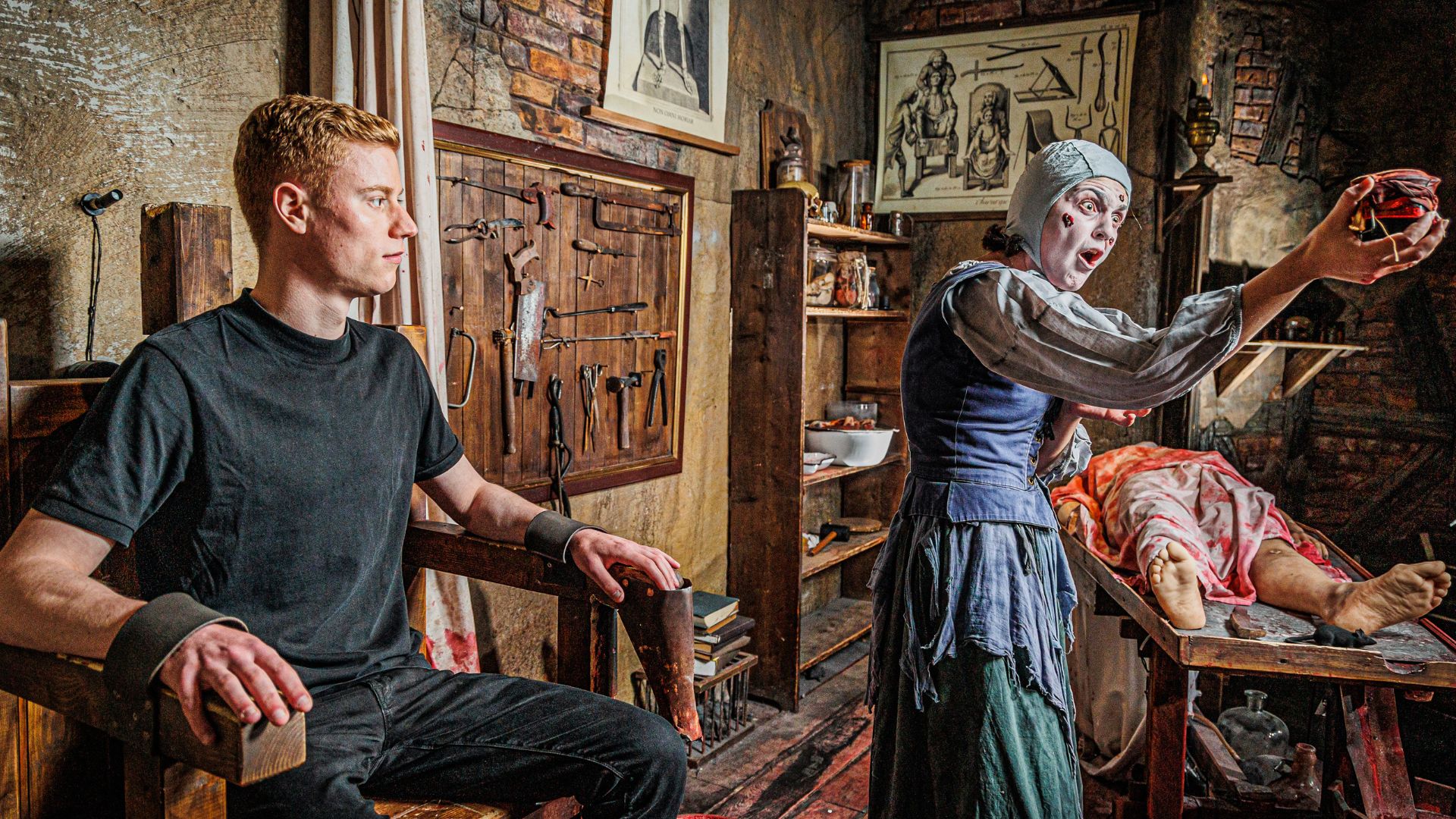 Discover how rife the Black Plague was in 1665 and the hideous symptoms people endured. Image courtesy of The London Dungeon. theatre set of a medieval doctors, with a visitor sat in a shackled chair and an actor pulling out a mannequins insides