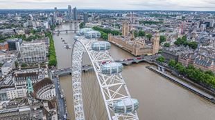 Aerial view from the London Eye showing capsules on the wheel above the River Thames, with Westminster Bridge and the Houses of Parliament.