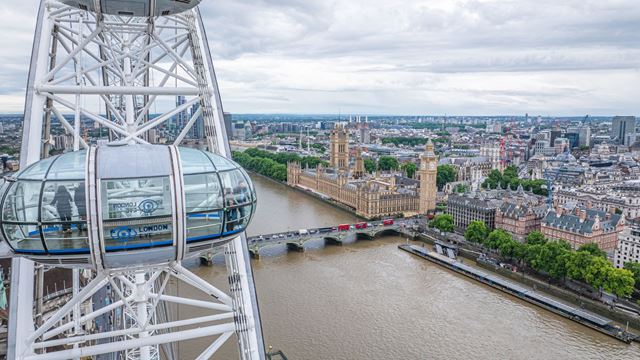 Step onto the London Eye for 360-degree views of London. © London & Partners/Michael Barrow Two people walk in front of the pods of the London Eye.