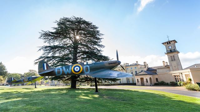 Trace the Battle of Britain story at Bentley Priory Museum. Image courtesy of Bentley Priory Museum. Spitfire and Hurricane planes on stands outside Bentley Priory Museum on bright day, with the museum in the background.