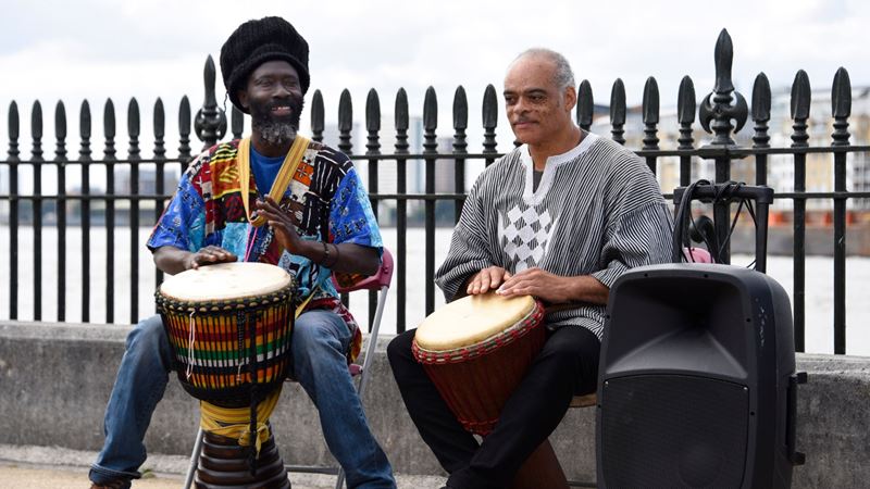 Mark International Slavery Remembrance Day at the National Maritime Museum on 23 August. Image credit: National Maritime Museum, Greenwich, London. Image courtesy of the National Maritime Museum. Two men play the drums dressed in traditional clothing to mark International Slavery Remembrance Day.
