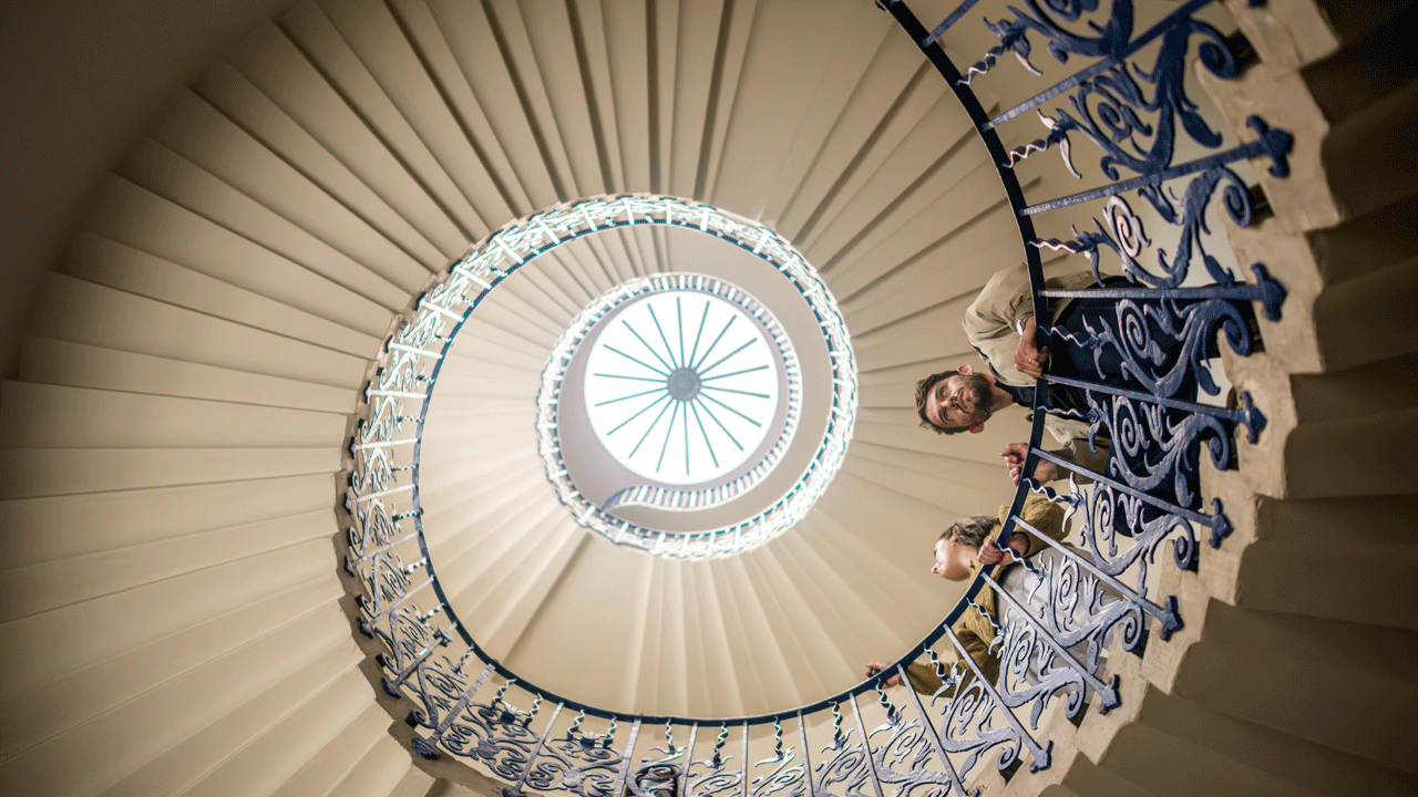 Admirez la fameuse cage d'escalier , la Tulip Staircase, à la Queen's House, un lieu historique à Greenwich. Avec l'aimable autorisation de London & Partners/Michael Barrow Un homme et une femme se penchent du haut d'un escalier en colimaçon depuis la Queen's House sur Greenich