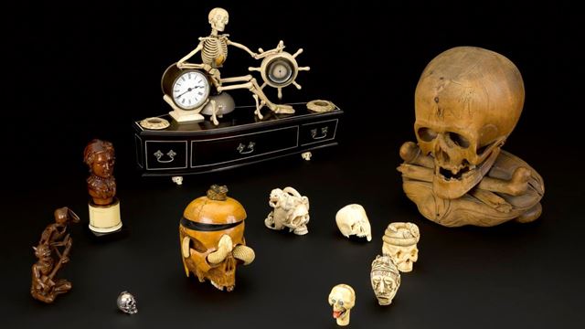 Skulls, antique clocks and other spooky artefacts displayed against a black background