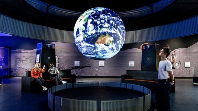 Visitors looking at Science on a Sphere in the Space gallery at the Science Museum.