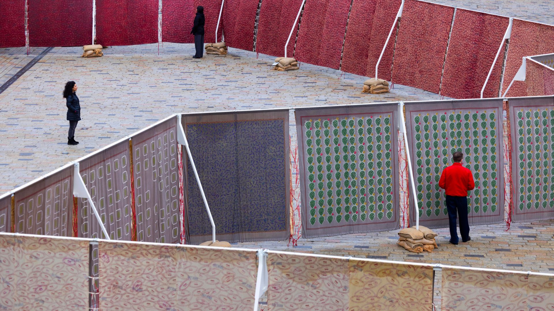 People standing either side of a fabric installation in the courtyard of Somerset House.