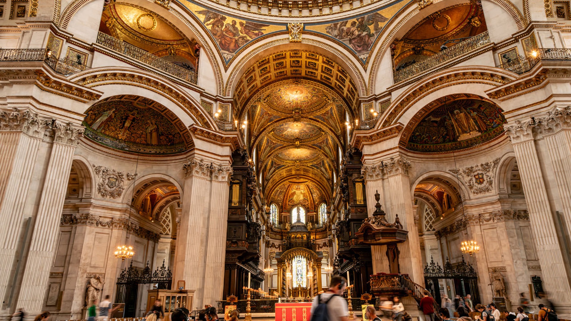 Visitors roam the walls of St Paul Cathedrals admiring its high ceilings.