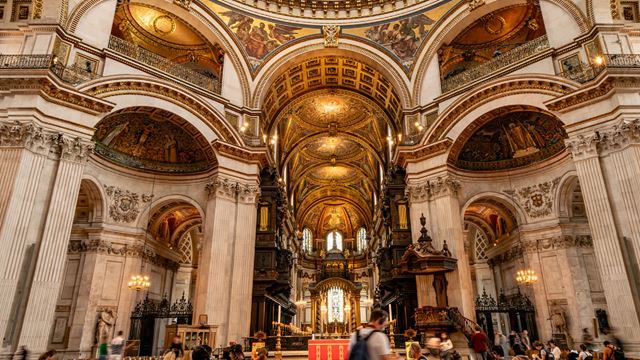 Visitors roam the walls of St Paul Cathedrals admiring its high ceilings.