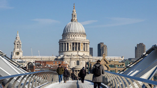 St Paul's Cathedral und die Millennium Bridge mit Schnee an einem sonnigen Tag.