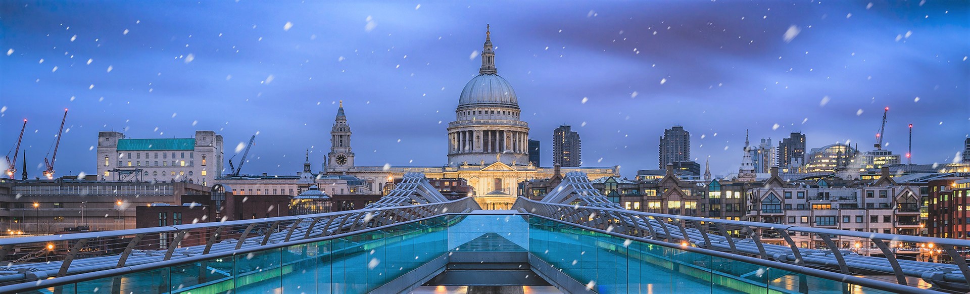 Blick auf die St. Paul's Cathedral an einem verschneiten Abend von der Millennium Bridge aus