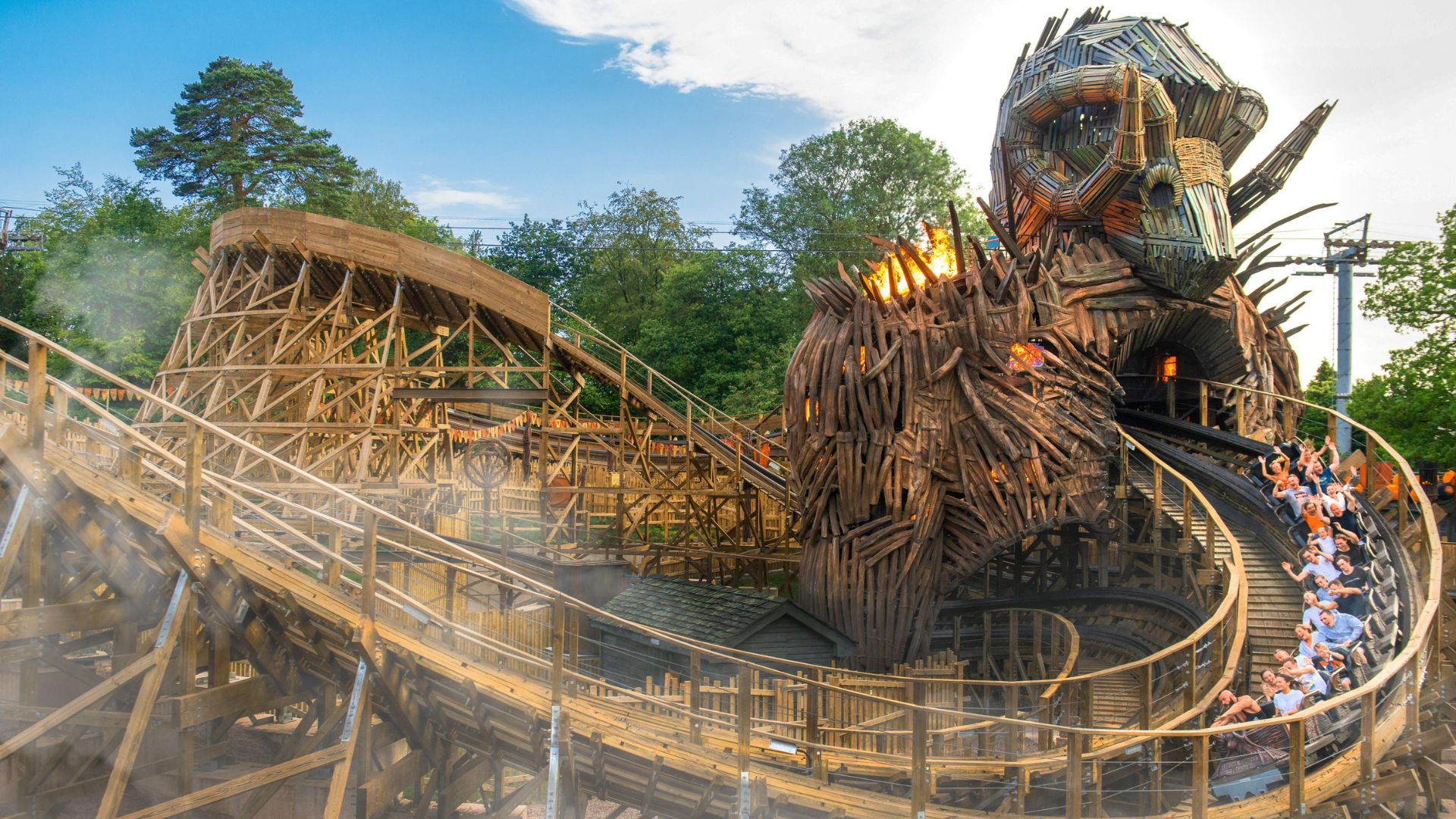 The Wicker Man wooden roller coaster at Alton Towers, with the train passing through a giant flaming wicker structure.