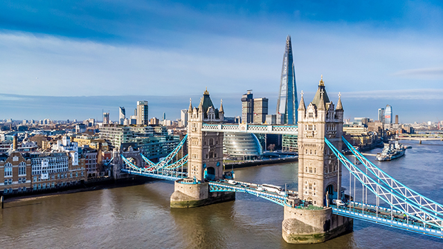 An aerial view of Tower Bridge and the Shard © Shutterstock / Photos.London . Image courtesy of Shutterstock / Photos.London. An aerial view of Tower Bridge on a bright day, with The Shard and City Hall in the background.
